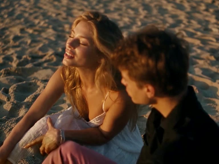 Raindance AI example: a couple on a wooden pier and a sunset beach, she sings to the camera
